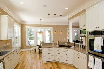 beautiful kitchen and dining room with wood floors and large windows
