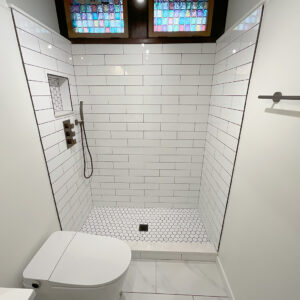 Shower and stained glass window in remodeled Chicago bathroom